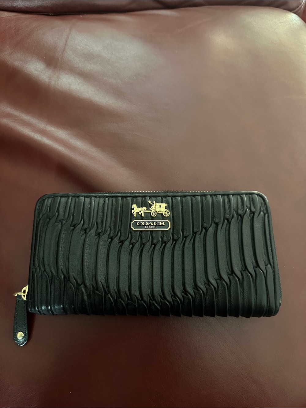 Coach Black Quilted Leather Zip-Around Wallet with Gold Logo.